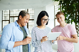 eine frau und zwei männer lächeln im büro