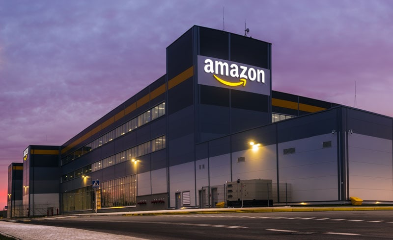 Amazon-Logistikzentrum bei Dämmerung mit beleuchtetem Logo