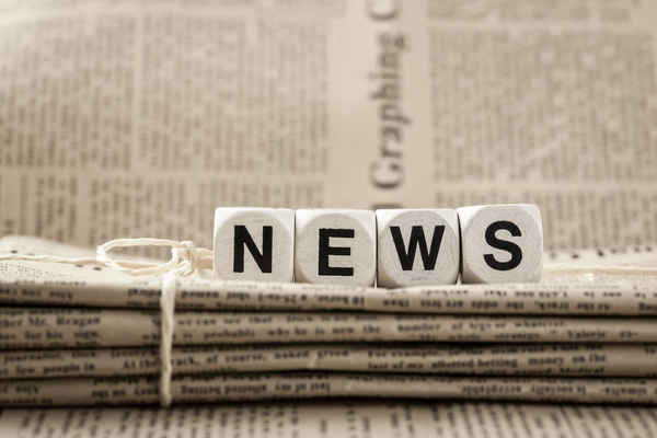 Nahaufnahme von Zeitungsstapeln mit Aufschrift „NEWS“