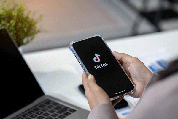 Hand hält Smartphone mit TikTok-Logo